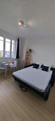 une chambre avec un grand lit et une table dans l'établissement Charmant Studio Cosy Confort, à Alfortville