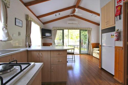 a kitchen with wooden cabinets and white appliances at BIG4 Crystal Brook Tourist Park in Doncaster East