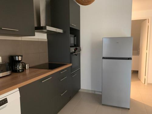 une cuisine avec un réfrigérateur blanc dans une pièce dans l'établissement Chez rose, à Brive-la-Gaillarde