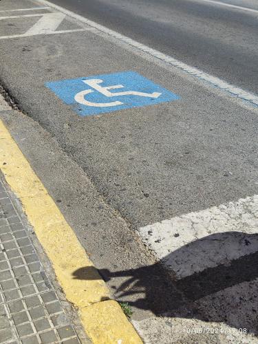 a blue handicapped sign on the road in a street at Apartamentos Luxury Play Victoria in Cádiz