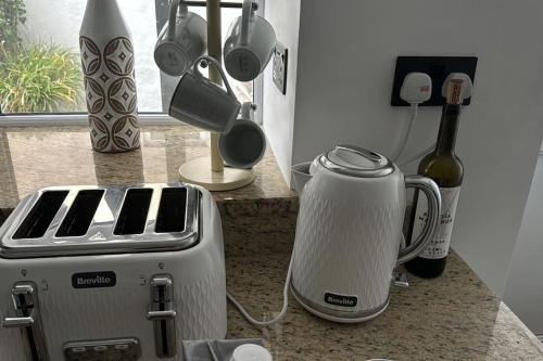a kitchen counter with a toaster and a bottle of wine at Stylish & central apartment close to the beach in Penzance