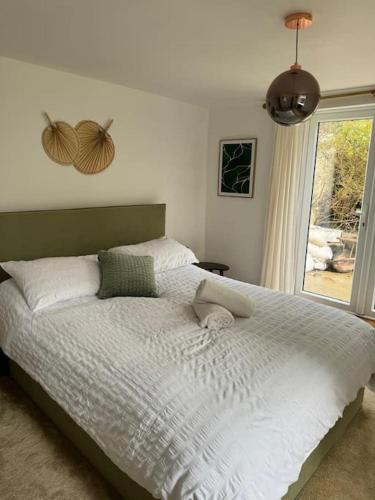 a bedroom with a large bed with a window at Stylish & central apartment close to the beach in Penzance