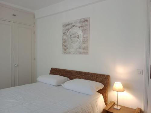 une chambre avec un lit et un tableau au mur dans l'établissement Le Pavillon de Flore, à Antibes