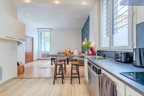 - une cuisine avec une table et quelques tabourets dans l'établissement Chic Family - Neuf & Moderne - Parking Wifi Centre Ville Gare TGV - Confort idéal Famille - OFFRE SPECIALE, à Perpignan