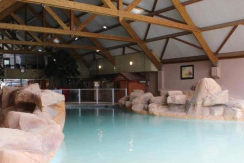 - une piscine dans un complexe avec un mur de roche dans l'établissement Mobilhome camping 4 étoiles proche plage, à Quend