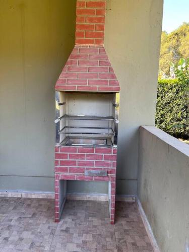 a brick oven sitting on the side of a building at Tranquilo e perto de tudo em SR in São Roque