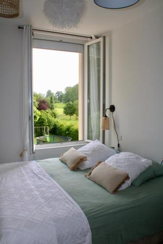 une chambre avec un lit avec une grande fenêtre dans l'établissement Les Sous Bois, à Saint-Laurent-de-Brévedent