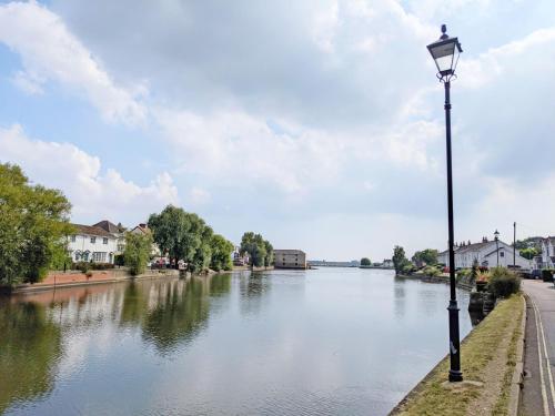 a street light next to a river with houses at Valetta Park in Emsworth