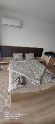 a bedroom with a bed with two shoes on it at SEA WOLF Apartman Луксозен апартамент с панорамна гледка към морето климатик с нова напълно оборудвана кухня отделна баня с тоалетна гледка към басейна на 30 м от плажа Паркинг към хотела Навсякъде близо in Lozenets