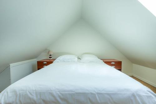 a bedroom with a large white bed with two dressers at Maisonnette cosy proche des 2 Gares et du centre ville Orléans in Orléans
