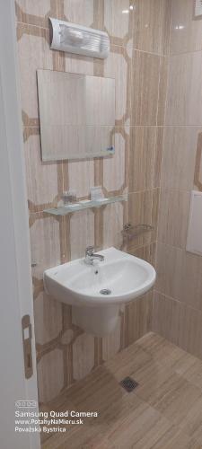 Un baño con un lavabo blanco y un espejo. en SEA WOLF Apartman Луксозен апартамент с панорамна гледка към морето климатик с нова напълно оборудвана кухня отделна баня с тоалетна гледка към басейна на 30 м от плажа Паркинг към хотела Навсякъде близо, en Lozenets