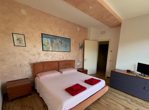 a bedroom with a bed with two red pillows on it at Casa Vacanze Al Cielo 2 in Sarnano