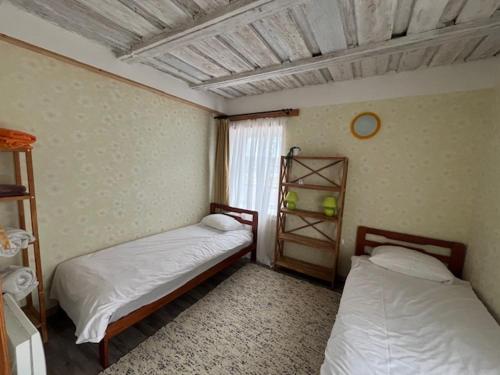 a room with two beds in a room with a window at Ostsee Apartments in Ventspils