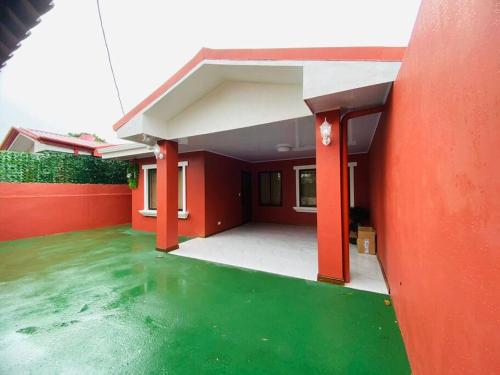 a house with a green floor and red walls at Berni's Deluxe Villa in Tanque