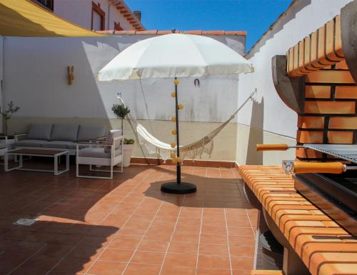 un patio con hamaca y sombrilla en Casa Mauro, en Oliva de Plasencia