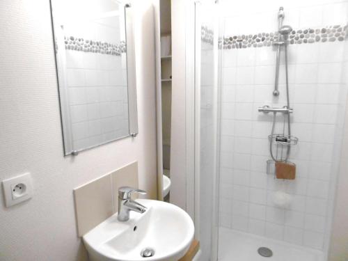 une salle de bain avec un lavabo et une douche avec un miroir dans l'établissement Appartement 2 à 4 personnes - LOMIG, à Sarzeau