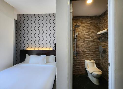 a bedroom with a white bed and a shower at Izumi Hotel Bukit Bintang Kuala Lumpur in Kuala Lumpur