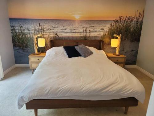 a bed in a bedroom with a painting of the ocean at ReTreat yourself in Port Franks in Lambton Shores