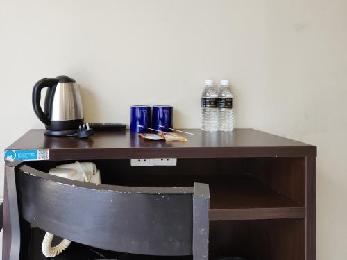 a desk with a coffee maker and water bottles on it at Izumi Hotel Bukit Bintang Kuala Lumpur in Kuala Lumpur