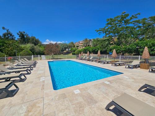 une piscine avec des chaises longues et un complexe hôtelier dans l'établissement CARDELLINI 30 - Piscine en résidence -Vue mer - 2 Personnes, à Kamiesch