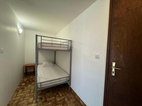 Cette petite chambre d'angle comprend des lits superposés. dans l'établissement Résidence la piscine, au Barcarès