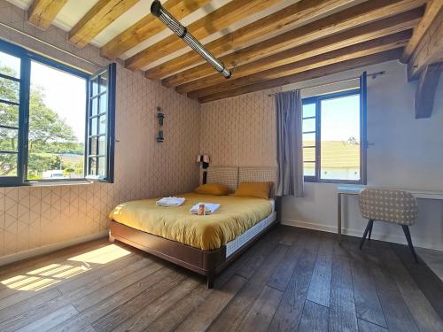 a bedroom with a bed and two windows and a chair at Villa d'exception, 5 chambres, 20m plage, spa. in Bénerville-sur-Mer