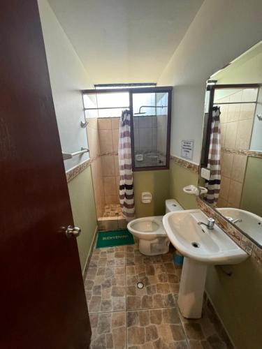 ein Badezimmer mit Waschbecken und Toilette in der Unterkunft Bungalow de 01 piso en casa de campo El Valle Inn in Cieneguilla