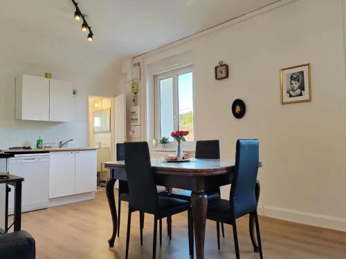 une cuisine et une salle à manger avec une table et des chaises dans l'établissement L'Art Nouveau près de Nancy, à Varangéville
