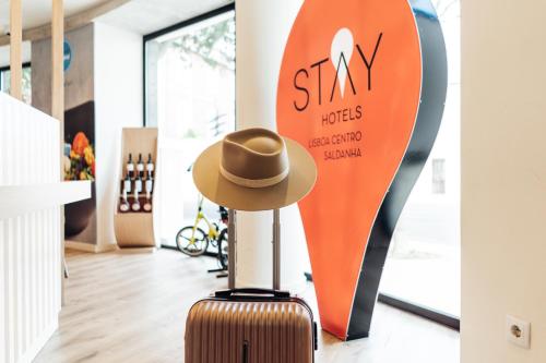 a hat on a suitcase in front of a surfboard at Stay Hotel Lisboa Centro Saldanha in Lisbon