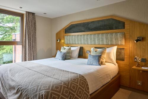 a bedroom with a large bed with a wooden headboard at Fairlawns, Hotel And Spa in Walsall