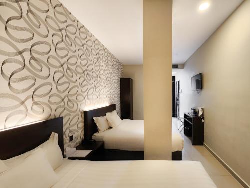 a bedroom with two beds and a wall with a mural at Izumi Hotel Bukit Bintang Kuala Lumpur in Kuala Lumpur