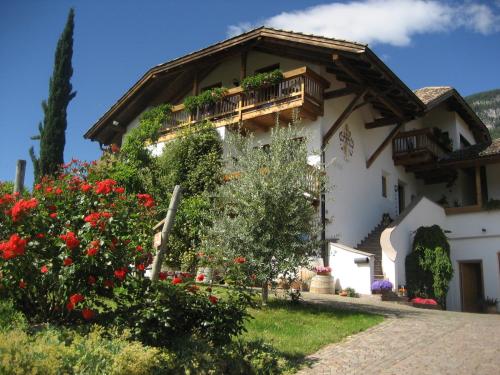 a house with a balcony and flowers in front of it at Gfillhof Ferienwohnung 3 in Eppan an der Weinstasse/St.Pauls