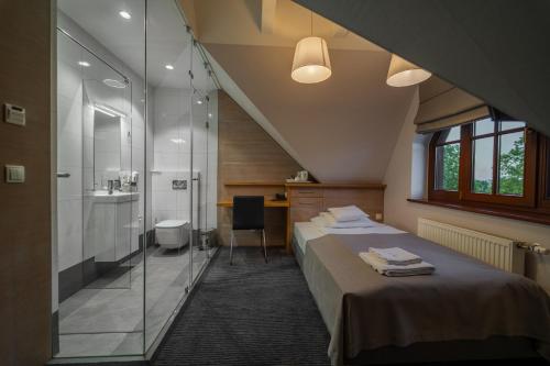 a bedroom with a bed and a bathroom with a shower at Hotel Salve in Głogówek