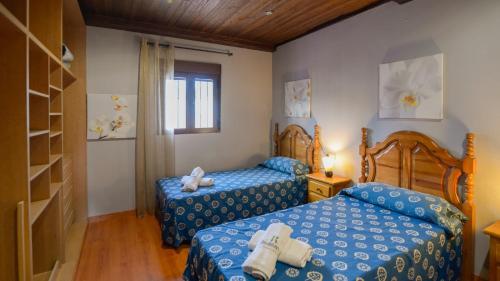 a bedroom with two beds and a book shelf at Capricho de Luna Atarfe by Ruralidays in Atarfe