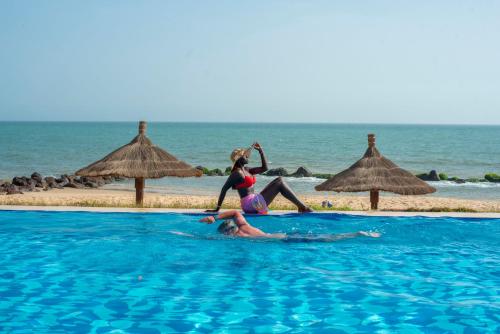 two women in a swimming pool near the beach at Royal Horizon Baobab in Somone