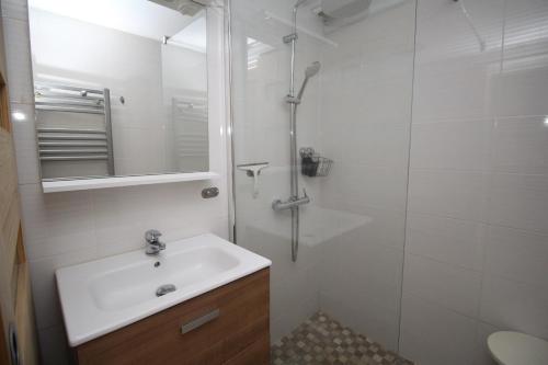 ein weißes Badezimmer mit Waschbecken und Dusche in der Unterkunft CORAUX - Maisonnette 4 pers avec piscine et parking in Canet-en-Roussillon