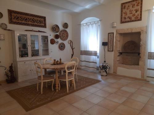 a dining room with a table and chairs and a fireplace at Domo Antiga Guest Rooms in Sorso
