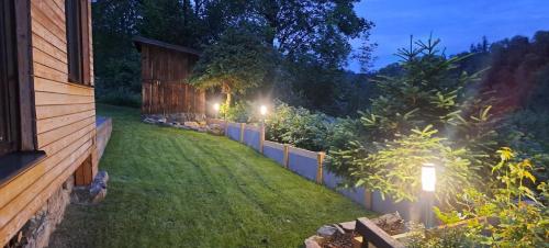 a backyard at night with lights on the grass at Chata Kateřinky in Korouhev