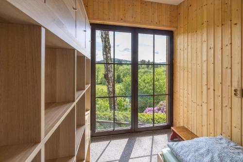 a bedroom with a large window in a wooden wall at Chata Kateřinky in Korouhev