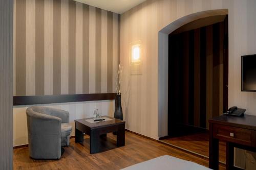 a hotel room with a chair and a table at Hotel Salve in Głogówek