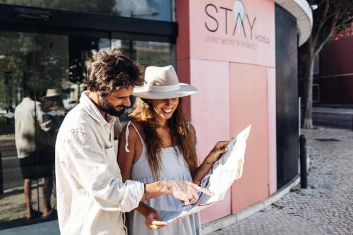 a man and a woman looking at a map at Stay Hotel Lisboa Centro Saldanha in Lisbon