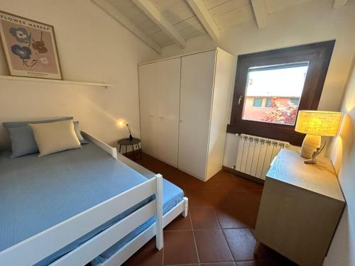 a bedroom with a blue bed and a window at Garda Golf Studio in Soiano del Lago