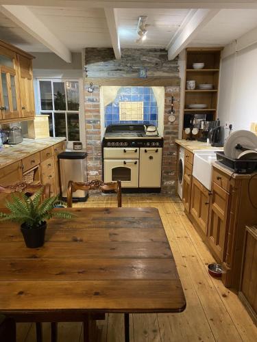 a kitchen with a wooden table and a stove at Jacobs Cottage in Port Isaac