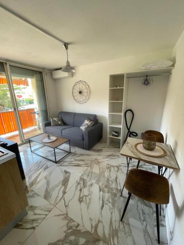 un salon avec un canapé bleu et une table dans l'établissement Studio Antibes Juan les Pins, à Antibes