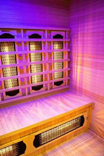 aitating room with purple lights and a wooden bench at Oázis Tapolca Apartman in Miskolctapolca