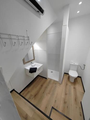 une salle de bain blanche avec des toilettes et un lavabo dans l'établissement L'Art Nouveau près de Nancy, à Varangéville