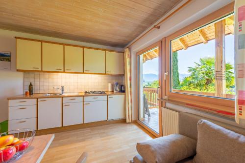 a kitchen with white cabinets and a large window at Gfillhof Ferienwohnung 3 in Eppan an der Weinstasse/St.Pauls