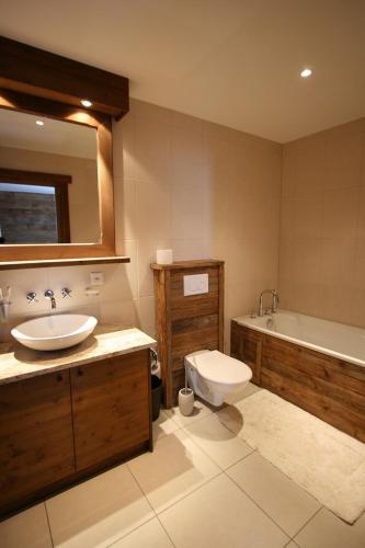 a bathroom with a sink and a toilet and a tub at Chalet Alouette in Grimentz