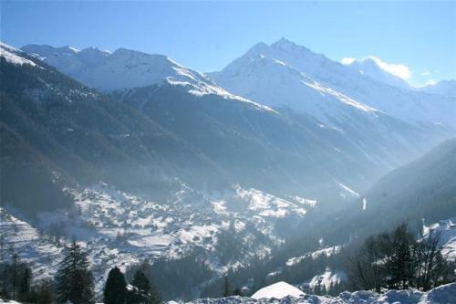 a view of a snowy mountain range with a city at Chalet Alouette in Grimentz