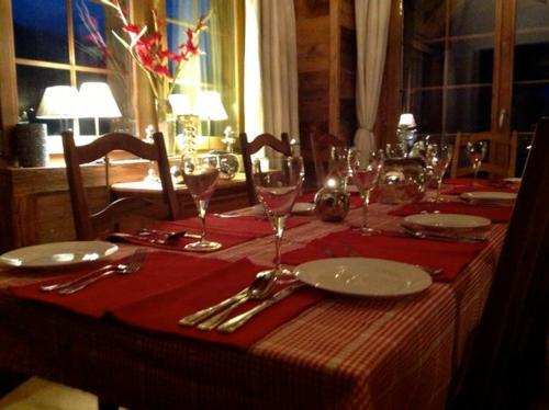 a table with a red table cloth and wine glasses at Chalet Alouette in Grimentz